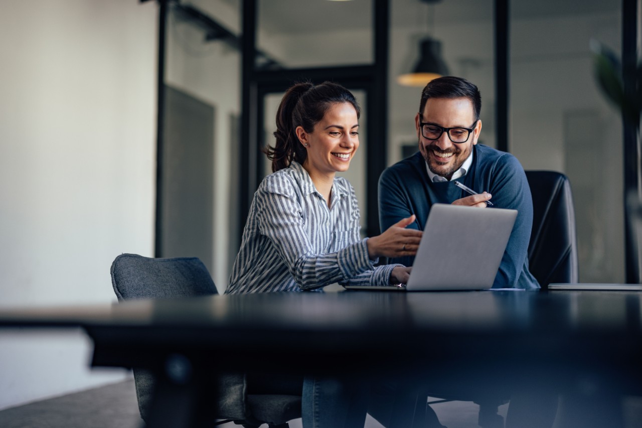 Two people looking at a laptop