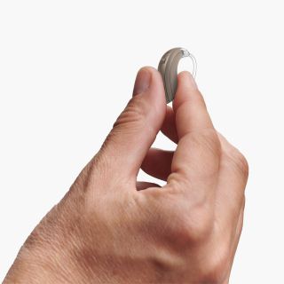 Hand holding BTE hearing aid