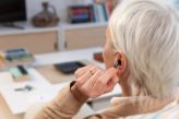 Woman inserting hearing aid