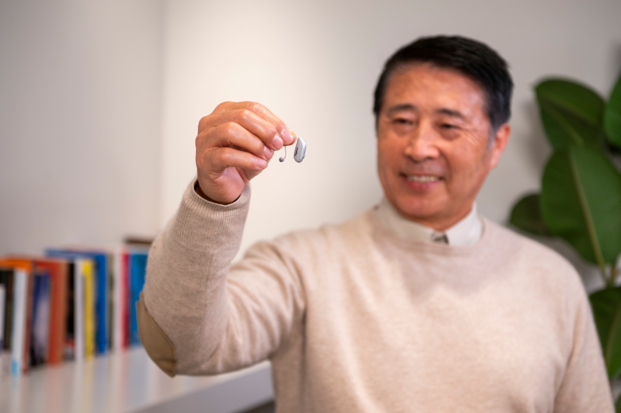 Man holding RIC hearing aid